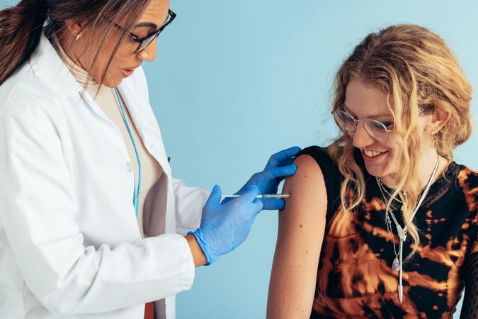 Woman receiving vaccine by a doctor