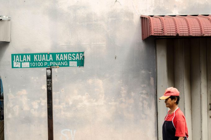 Person standing beside street sign in George Town, Penang, Malaysia