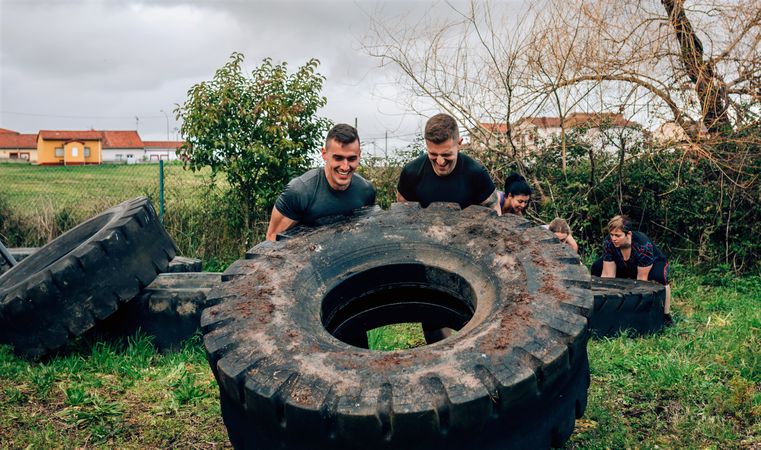 Participants in an obstacle course turning a wheel