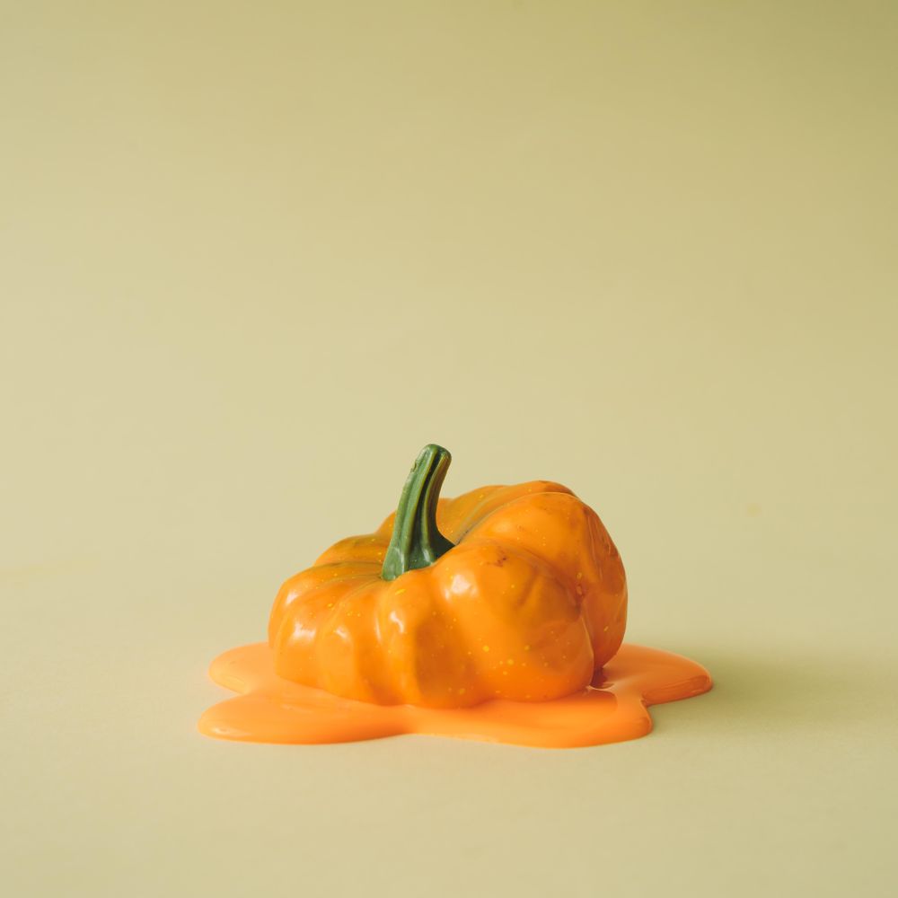 Melting pumpkin on beige background