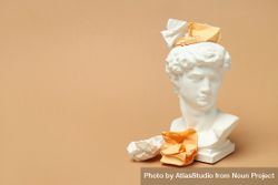 Marble bust with crumpled paper on brown background 4Mmoa4