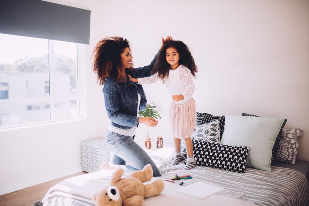 Mother and daughter playing on the bed