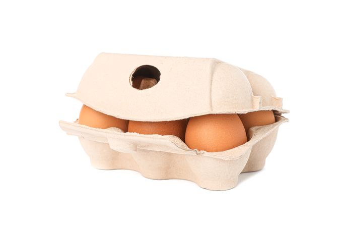 Brown chicken eggs in carton box isolated on blank background