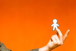 Smiling man holding funny paper toy