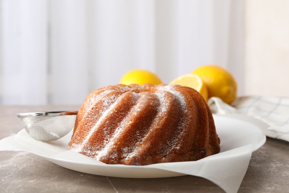 Cake with powder sugar on grey table, close up