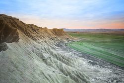 Stone desert hills near green field