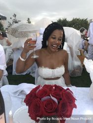 Bride smiling and holding a glass of wine surrounded by guests 5nveD5