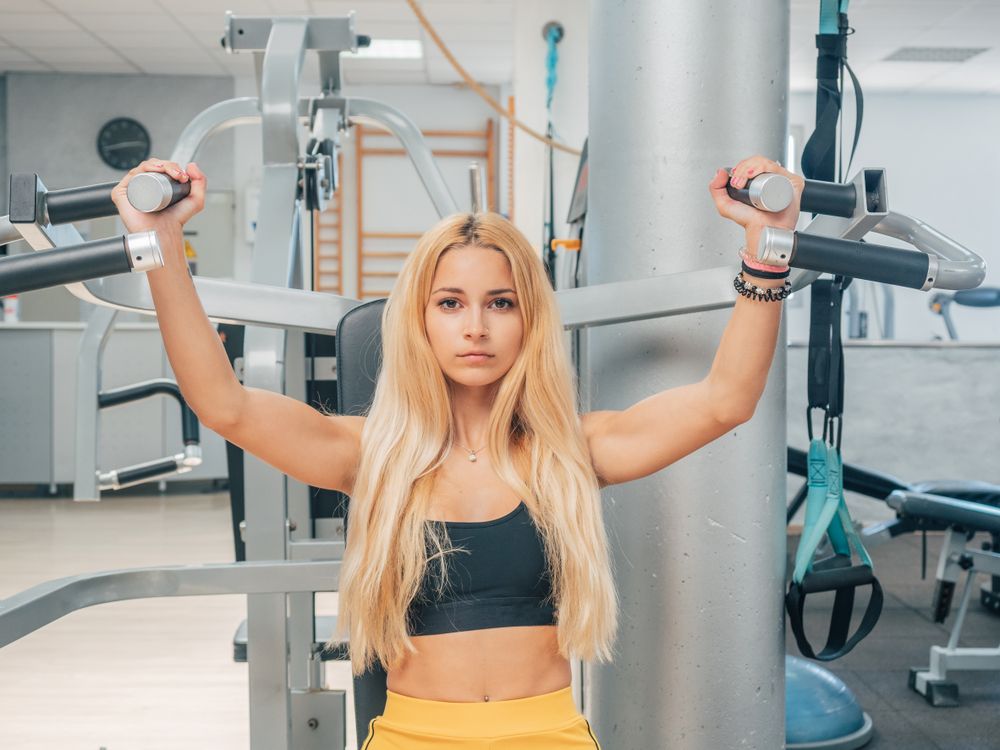 Slim woman exercising on resistance trainer