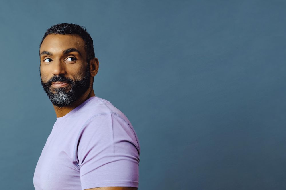 Serious male in purple t-shirt looking away, copy space