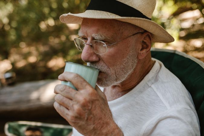 Close-up of a mature man having refreshing coffee at campsite