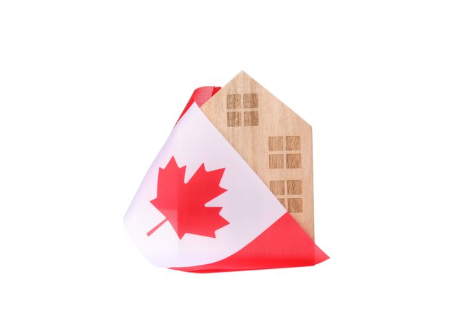Canadian flag with a wooden house, isolated on plain background
