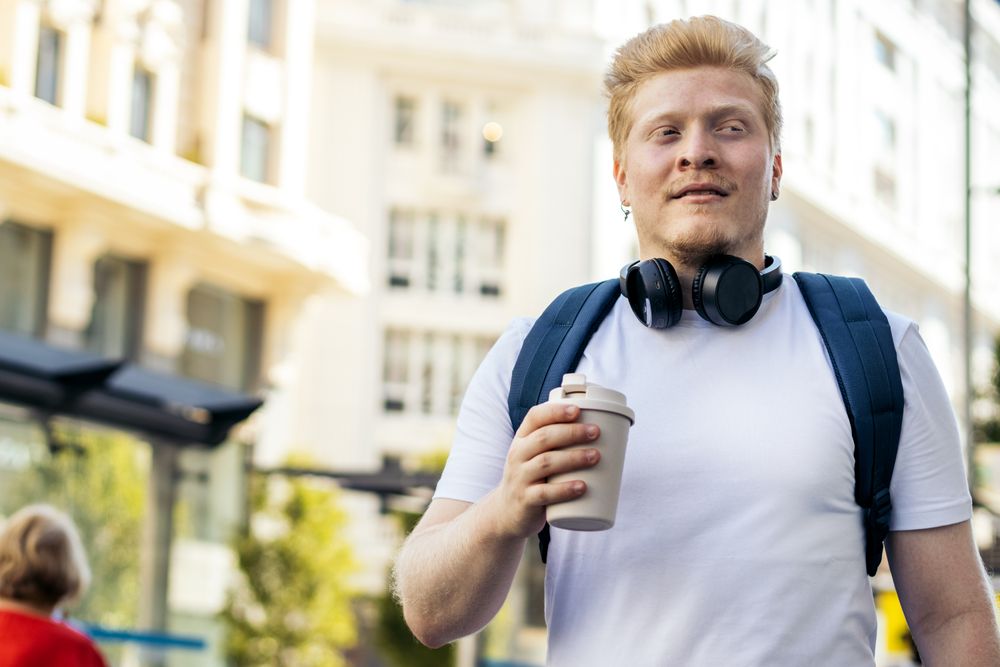 Young Latino man with albinism walking down the city street