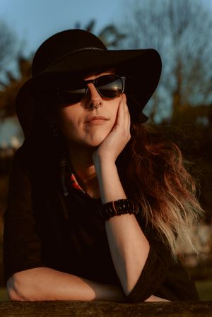 Dreaming stylish woman in sunglasses and hat