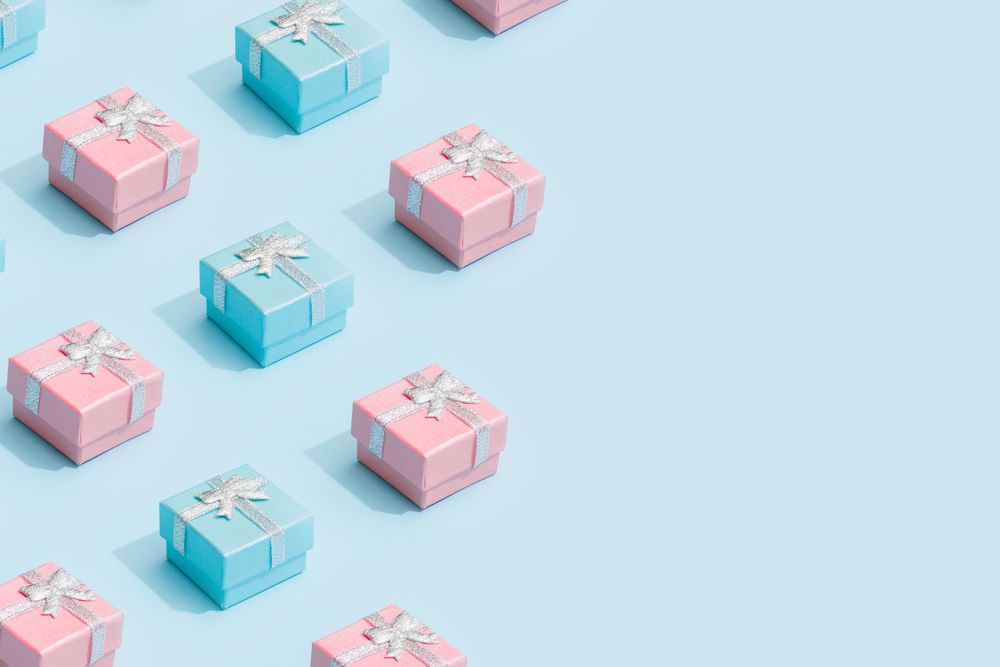 Pastel pink and blue ribbon wrapped presents on baby blue background