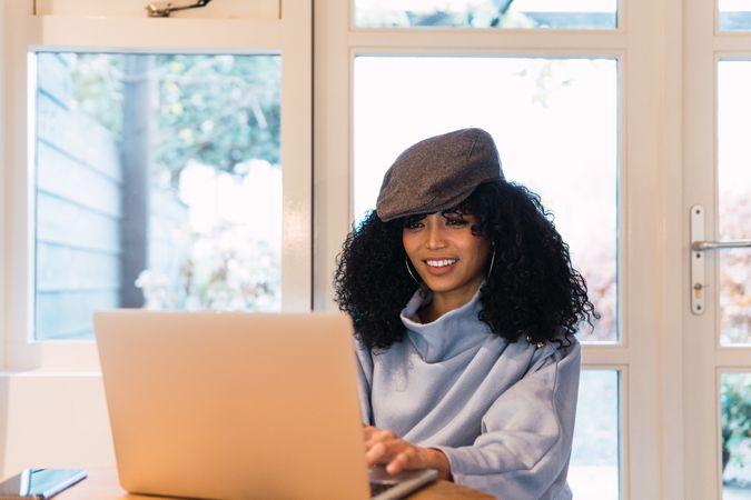 Smiling Black woman working on laptop