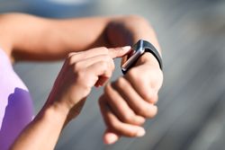Close-up of hands and wrist with smart watch screen