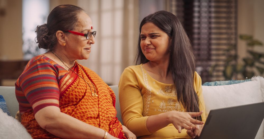 Excited Indian Mother and Daughter Using Laptop, Bonding Over Shared Interests