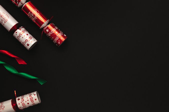 Christmas crackers with ribbons placed on dark background
