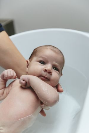 Newborn in the bathtub looking at camera