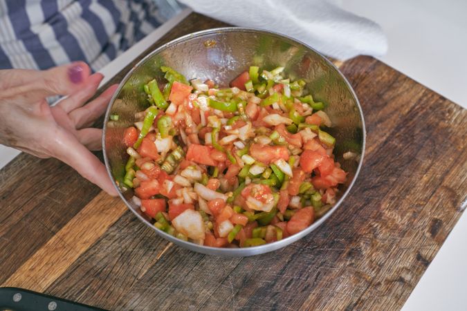 Unrecognizable woman with bowl of chopped vegetables