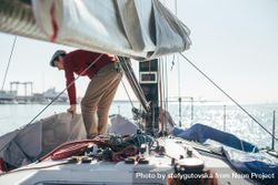 Man arranging boat covering on a yacht 4ORzJ5