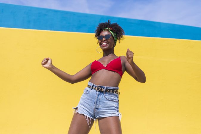Fun Black woman laughing with arms raised