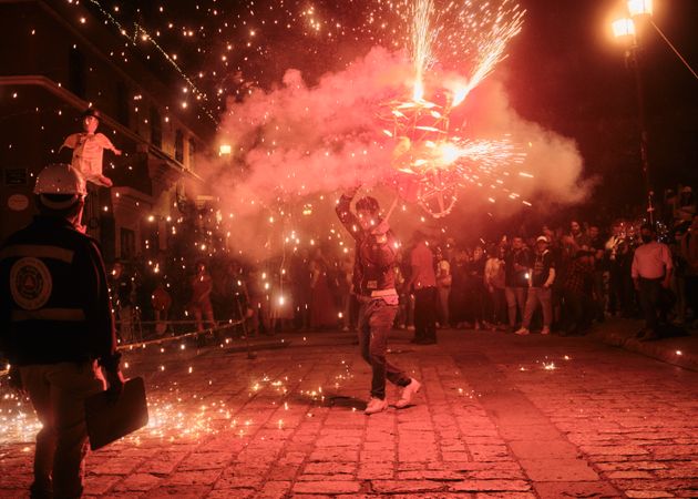 Man holding figure doing fireworks display at street festival
