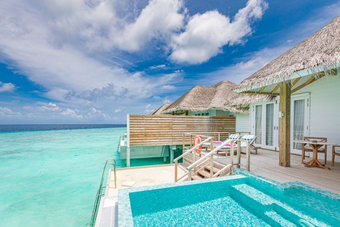 Patio of holiday villa with pool over looking a clear ocean