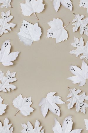 Flat lay Halloween background made with autumn leaves as ghosts