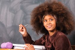 Black schoolgirl at desk in classroom