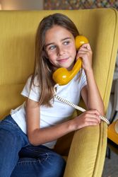 Positive girl speaking on vintage landline phone