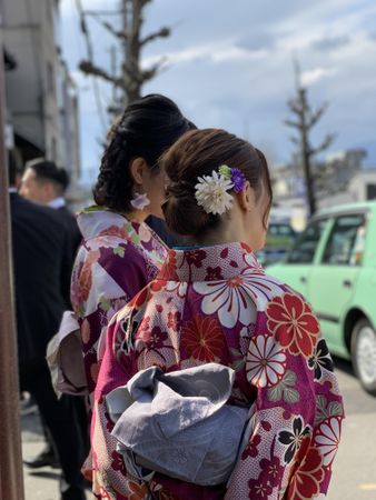 Two women in kimonos standing outdoor