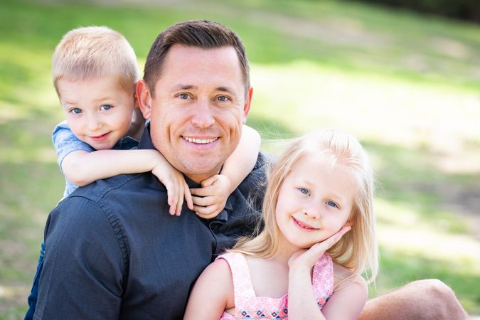 Young Dad, Son and Daughter Having Fun In The Park