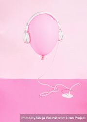 Pink balloon wearing headphones plugged into pink desk 5lkwe0