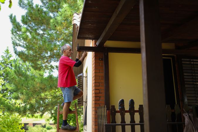 Mature man in his late sixties repairing his home.