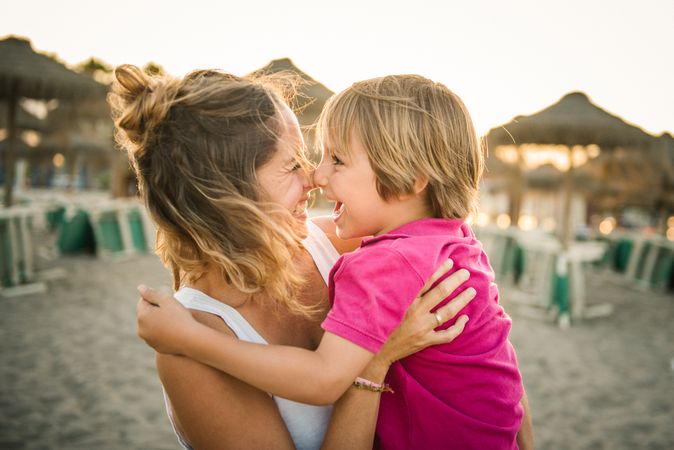 Woman with naughty boy on hands on beach