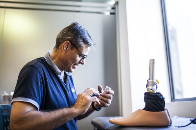 man fixing a prosthesis in a workshop