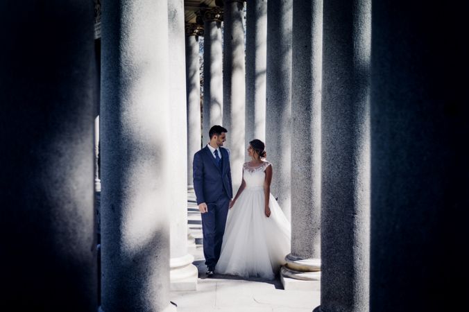 Newlyweds walking near columns