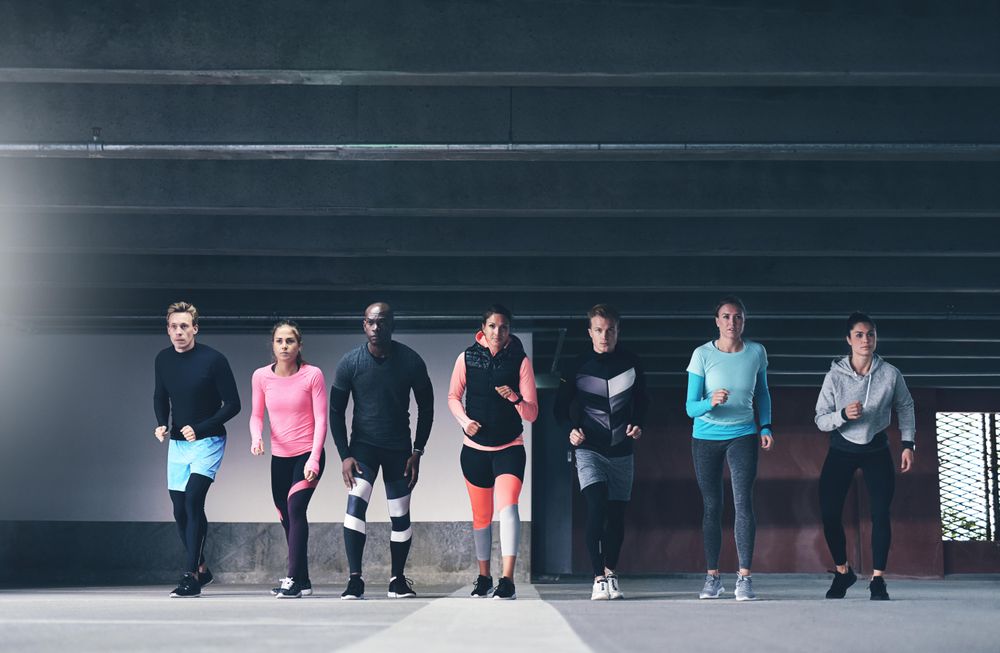 Multi-ethnic group of people lining up in a row running