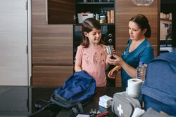 Mother preparing emergency backpack with her daughter