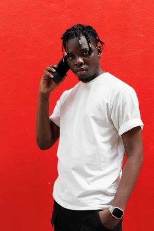 Man talking on the mobile phone standing on red background