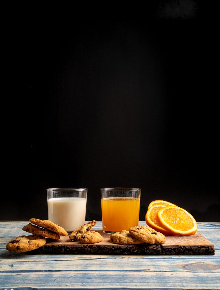 Glasses near fruits and cookies on table near napkin