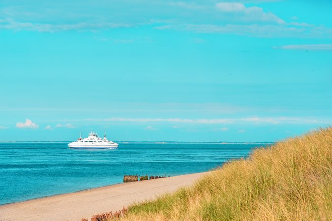 Landscape with boat on North Sea and the Sylt island beach
