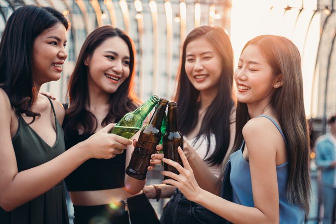 Group of happy Asian friends celebrating party beers at rooftop party