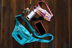 Flat lay of fanny pack with items laid out on table