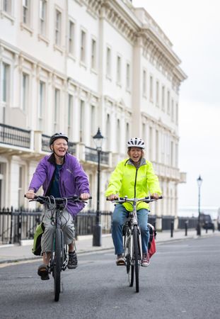 Two mature people rising bikes through British town