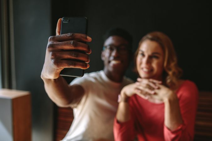 Smiling couple taking a selfie using mobile phone