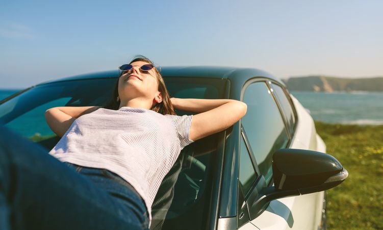 Young woman lying on the windshield