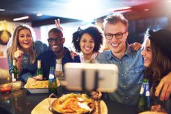 Multi-ethnic group of smiling people posing for a photo at a bar