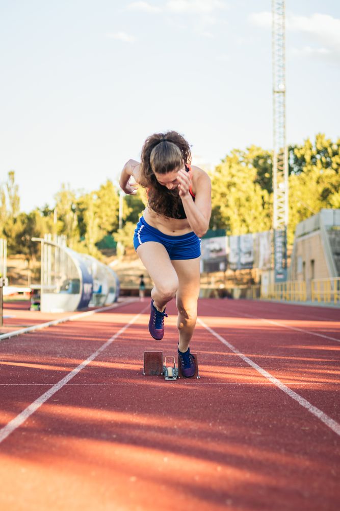 female athlete running on an athletics track.